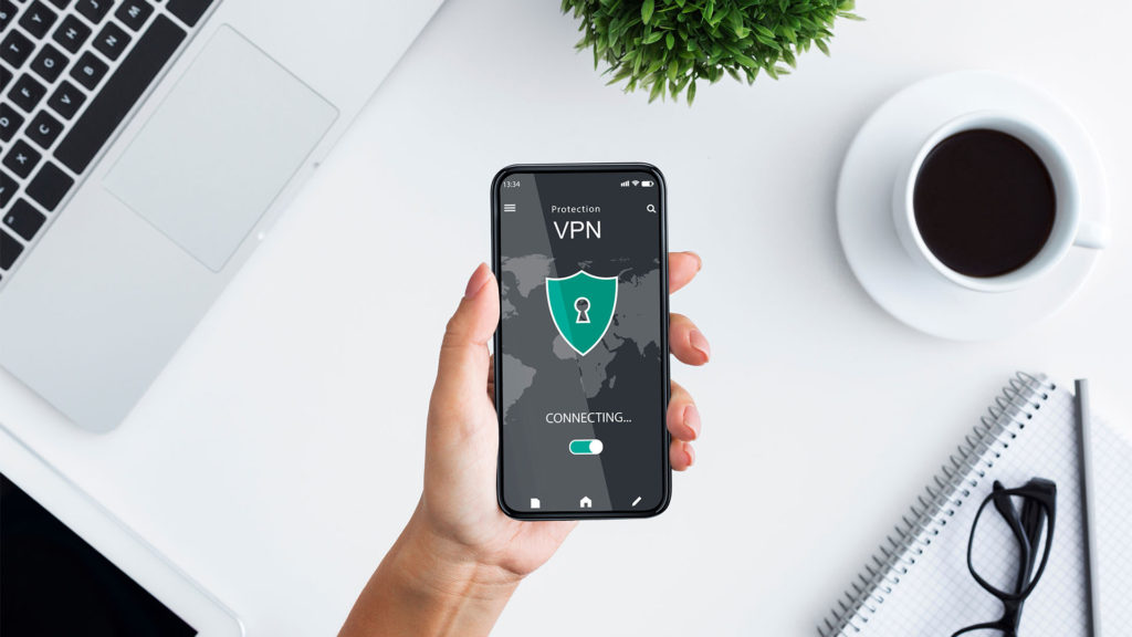 Quais os benefícios da VPN? Pessoa com celular em mãos acessando uma rede VPN
