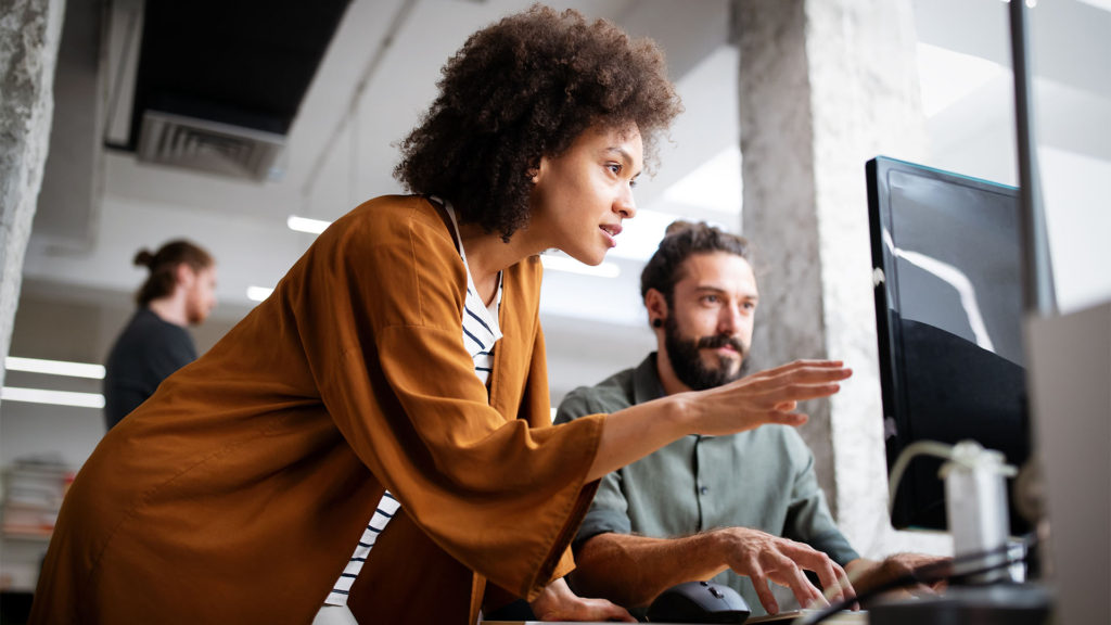 Apps e serviços de tecnologia para empresas - mulher ajudando colega de trabalho com o computador