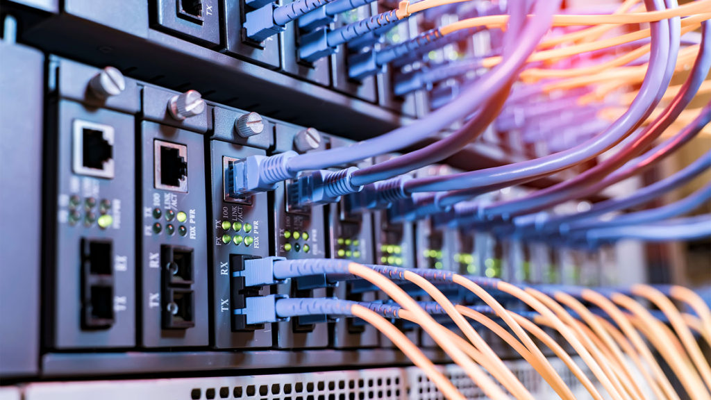 Imagem de rack de servidores firewall com cabos de rede conectados.