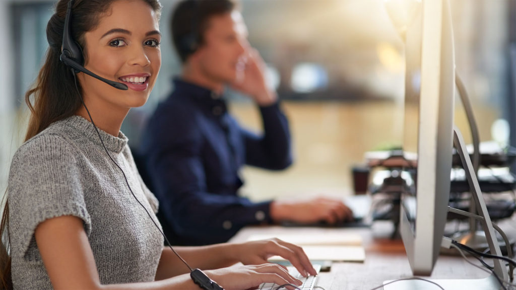 Mulher fazendo atendimento de TI através do telefone. Saiba como uma boa terceirizada em TI pode ajudar o seu negócio a se adequar a LGPD.